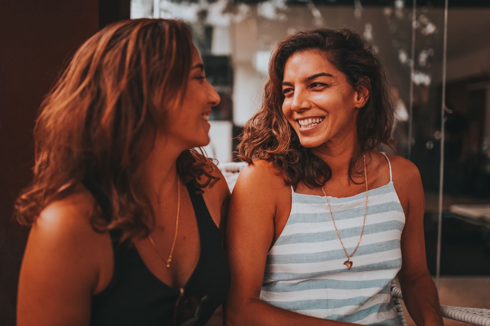 Dos mujeres conversando y sonriendo